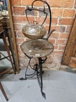 AN ARTS AND CRAFTS COPPER KETTLE AND BURNER ON AN ART NOUVEAU WROUGHT IRON TRIPOD STAND, THE