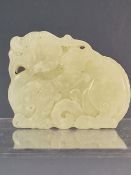 A CHINESE NEPHRITE JADE PENDANT CARVED AS A RECLINING QILIN. W 5cms.