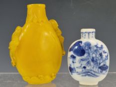 A CHINESE AMBER GLASS SNUFF BOTTLE, THE STIFF LEAF RIM BAND ABOVE BAT HANDLES AND A WAVE FOOT BAND
