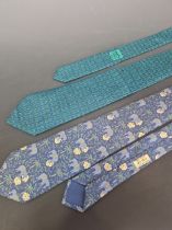 TWO HERMES BLUE GROUND SILK TIES, ONE WITH ELEPHANTS AND THE OTHER WITH GREEN FIGURE OF EIGHT KNOTS