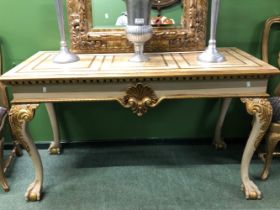A GILT DETAILED CREAM GROUND CONSOLE TABLE, THE RECTANGULAR TOP OVER A SHELL CENTRED APRON AND