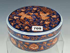 A CHINESE IRON RED AND UNDERGLAZE BLUE WRITING BOX AND COVER, THE CIRCULAR LID OPENING ONTO A