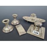 A PAIR OF HALLMARKED SILVER DWARF CANDLESTICKS, AN ENGINE TURNED CARD CASE, A SILVER CAPPED GLASS