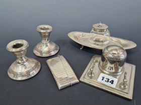 A PAIR OF HALLMARKED SILVER DWARF CANDLESTICKS, AN ENGINE TURNED CARD CASE, A SILVER CAPPED GLASS