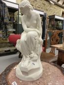 SOLITUDE: A MINTON J LAWLOR PARIAN FIGURE OF A PARTIALLY DRAPED LADY SEATED ON A ROCK ABOVE A LONG