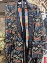 A BLACK GROUND SILK DRESSING GOWN MACHINE WOVEN IN COLOURS WITH CHINOISERIE