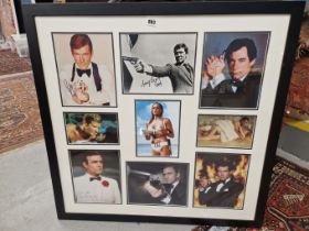 JAMES BOND ACTORS: A FRAME OF NINE PHOTOGRAPHS, SIX SIGNED, THE GROUP ARRANGED ABOUT URSULA