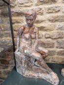 A COPPER PATINATED PLASTERFEMALE NUDE SEATED ON A STONE BLOCK. H 55cms.