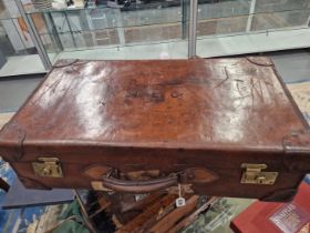 AN EARLY 20th C. LEATHER SUITCASE WITH BRASS LOCK PLATES