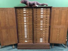 A LATE 19th C. OAK COLLECTORS CUPBOARD, THE FOUR PANELLED DOORS ENCLOSING FORTY DRAWERS ABOVE THE