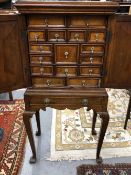 A LATE 19th C. MAHOGANY CABINET ON STAND WITH PANELLED DOORS ENCLOSING A CONFIGURATION OF DRAWERS,