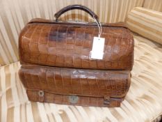 A CROCODILE LEATHER GLADSTONE DRESSING BAG WITH CANVAS OUTER COVER AND SILVER MOUNTED FITTINGS BY