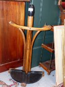 A BENTWOOD STICK STAND WITH REMOVABLE IRON DEMILUNE TROUGH BASE