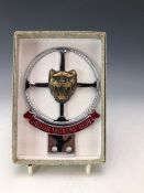 A CHROME JAGUAR OWNERS CLUB CAR BADGE MODELLED AS A STEERING WHEEL WITH A CENTRAL JAGUARS HEAD
