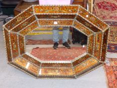 AN OCTAGONAL MIRROR WITHIN A FRAME OF THREE BANDS OF REVERSE PAINTED GLASS DECORATED WITH FLOWERS