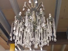 A TWO TIER CHANDELIER, THE LOWER TIER WITH TEN LIGHTS HUNG WITH PEAR SHAPED DROPS FROM STRINGS OF