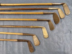 A BAG OF EIGHT HICKORY SHAFTED GOLF IRONS