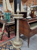 A FLOOR STANDING SILVERED METAL PRICKET CANDLESTICK WITH DISHED DRIP PAN AND CIRCULAR FOOT, THE