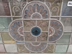 A LEADED GLASS WINDOW PANEL WITH A BLUE ROUNDEL SURROUNDED BY A PAINTED QUATREFOIL OF FOLIAGE. 65