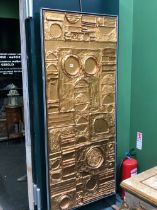 AN ALUMINIUM FRAMED GILT METAL PANEL WORKED IN RELIEF WITH GEOMETRIC SHAPES. 186 x 80cms.