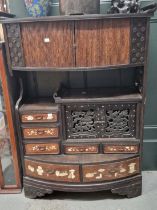 A JAPANESE CABINET WITH A BOW FRONTED TAMBOUR ENCLOSED SHELF TOP OVER DRAWERS WITH INLAID TEA POTS