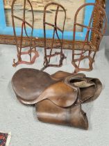 A SADDLE AND THREE IRON WALL FITTING SADDLE RACKS