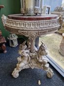 A 19th CENTURYMOTTLED RED MARBLE TOPPED GREY PAINTED TABLE SUPPORTED ON A COLUMN FLANKED BY THREE