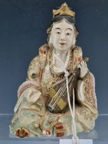 A JAPANESE SATSUMA POTTERY FIGURE OF A LADY SEATED HOLDING A LUTE. H 16.5cms.