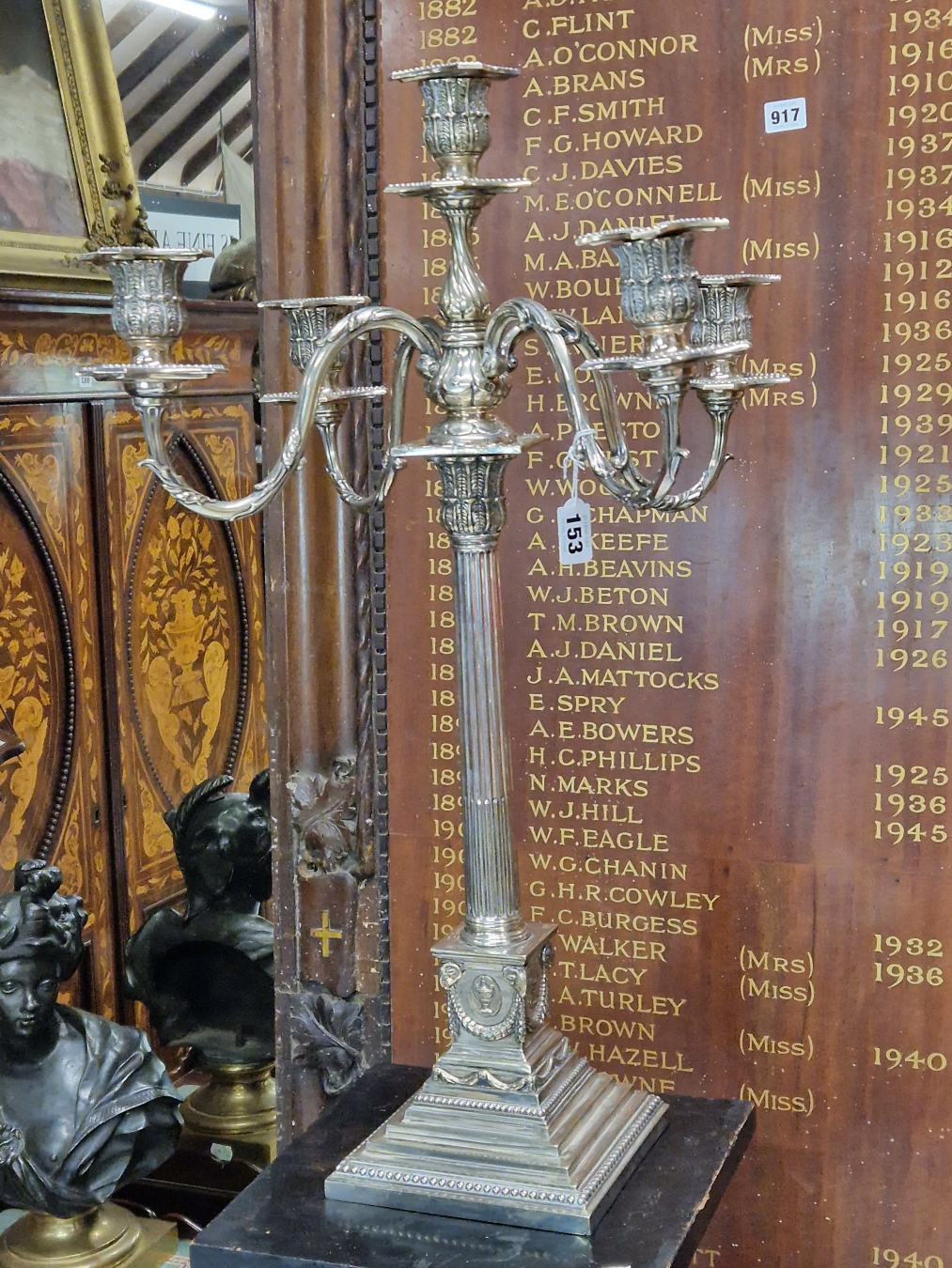 AN ELECTROPLATE FIVE LIGHT CANDELABRUM, THE STOP FLUTED COLUMN ON A PLINTH OF SWAGGED URNS AND A