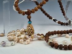 A MANDARINS NECKLACE, THE CRAVED NUT BEADS INTERSPACED WITH TUBULAR BANDED AGATE AND ENDING IN A