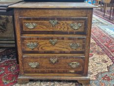 A ANTIQUEOAK CHEST OF THREE MAHOGANY CROSS BANDED LONG DRAWERS ON A PLINTH FOOT. W 68 x D 51 x H