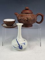 A YIXING TEA POT AND COVER, THE BUN SHAPED BODY WITH FLOWERS IN RELIEF, A TEA BOWL AND SAUCER WITH