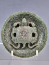 A CHINESE SPINACH JADE TRIPOD BOWL CENTRALLY CARVED IN RELIEF WITH A TURTLE HOLDING DOWN TWO SNAKES,