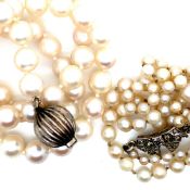 A CULTURED PEARL GRADUATED NECKLACE FITTED WITH A DIAMOND SET BOW CLASP. THE CLASP UNHALLMARKED,