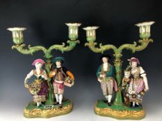 ATTRIBUTED TO EARLY VICTORIAN MINTON, A PAIR OF FIGURAL TWO LIGHT CANDELABRA, THE SUPPORTING COUPLES