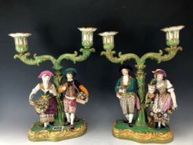 ATTRIBUTED TO EARLY VICTORIAN MINTON, A PAIR OF FIGURAL TWO LIGHT CANDELABRA, THE SUPPORTING COUPLES