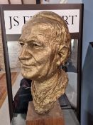 A GILT PLASTER BUST OF POPE JOHN PAUL II MOUNTED ON A WOODEN BLOCK BASE. H 57cms.