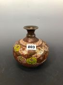 AN INDIAN ENAMELLED BRASS VASE, THE SHORT NECK ABOVE A BUN SHAPED BODY WITH A DIAPER OF FLOWER STEMS