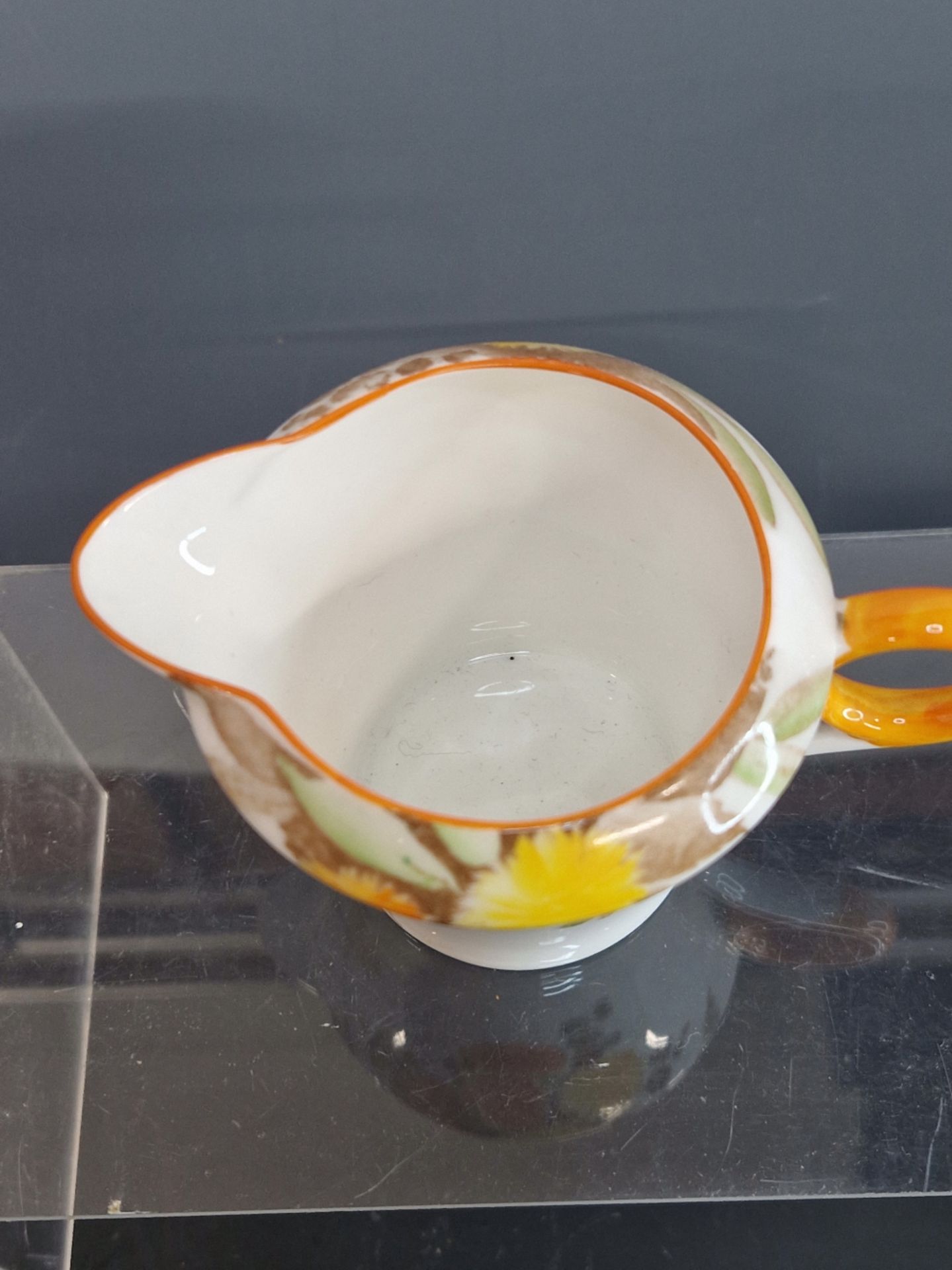 A SHELLEY TONED ORANGE CHAMBER STICK TOGETHER WITH A CREAM JUG WITH ORANGE AND YELLOW DAISIES - Image 6 of 7