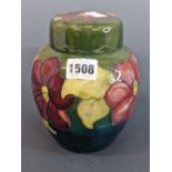 A MOORCROFT GREEN GROUND ANEMONE PATTERN JAR AND COVER, LABEL AND IMPRESSED MARK