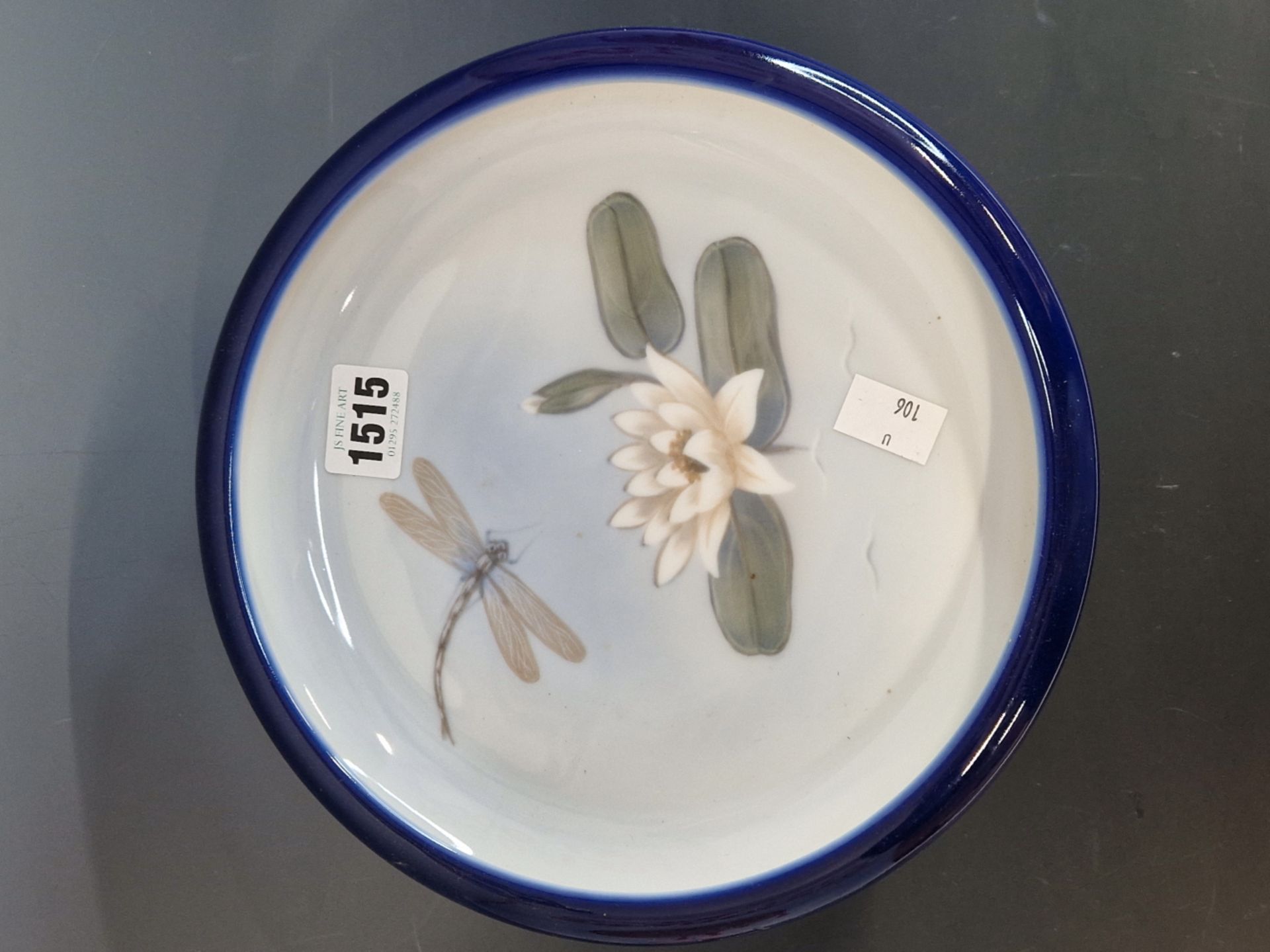 A COPENHAGEN SHALLOW BOWL DECORATED WITH A DRAGON FLY ABOUT TO LAND ON A WATER LILY. Dia. 24cms.