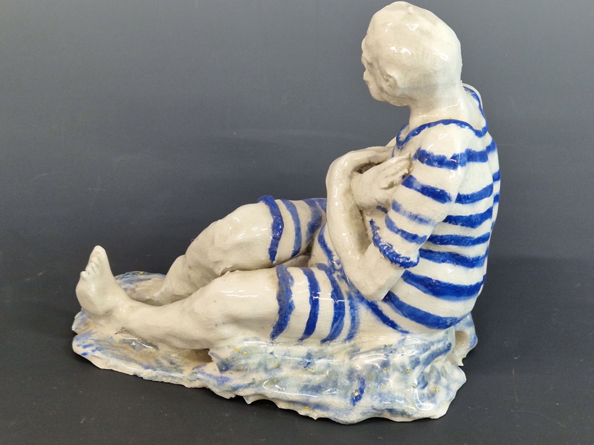 A STUDIO POTTERY FIGURE OF A MAN SEATED WEARING A BLUE STRIPED BATHING SUIT. W 22cms. - Image 4 of 4