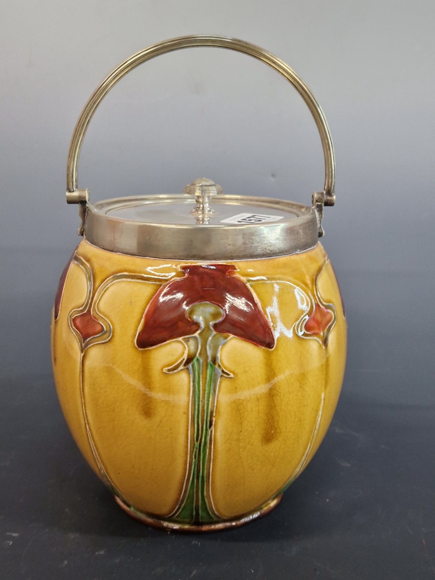 DOULTON?- AN ART NOUVEAU BISCUIT BARREL WITH SILVER PLATED MOUNTS. YELLOW GROUND BODY WITH