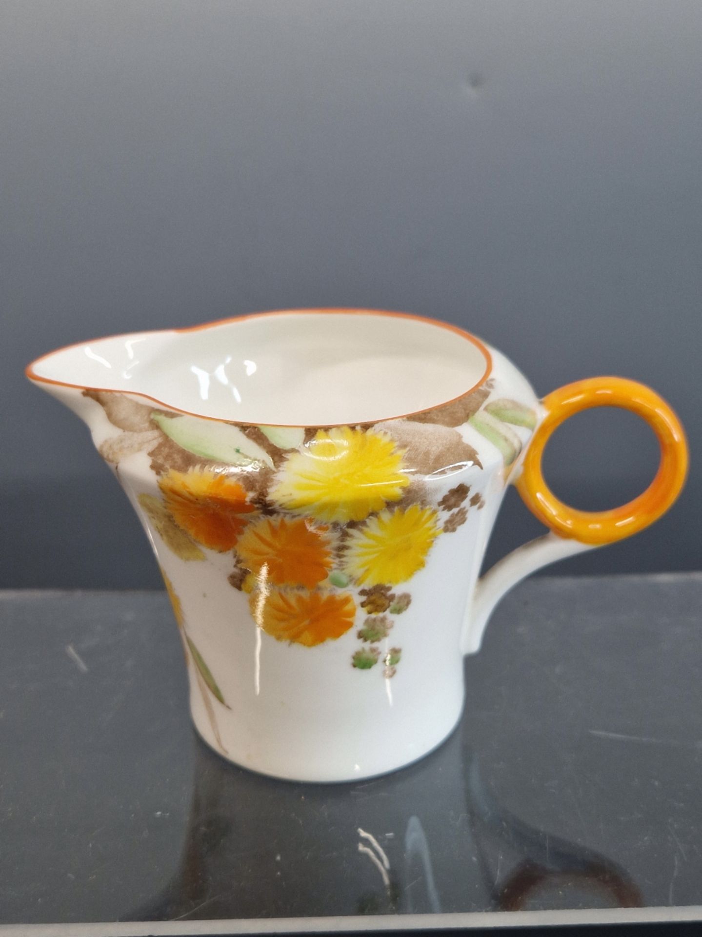 A SHELLEY TONED ORANGE CHAMBER STICK TOGETHER WITH A CREAM JUG WITH ORANGE AND YELLOW DAISIES - Image 5 of 7