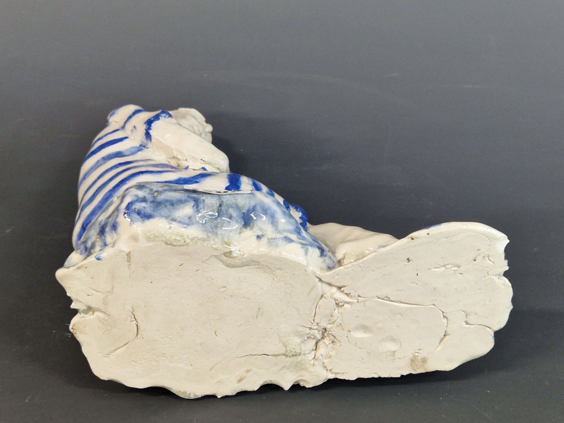 A STUDIO POTTERY FIGURE OF A MAN SEATED WEARING A BLUE STRIPED BATHING SUIT. W 22cms. - Image 3 of 4