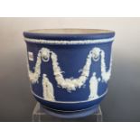 A WEDGWOOD BLUE DIP JASPER PLANTER WITH CLASSICAL FIGURES STANDING BELOW SWAGS OF GRAPES. Dia.