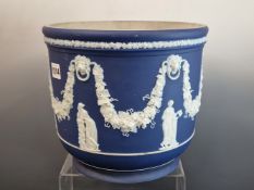 A WEDGWOOD BLUE DIP JASPER PLANTER WITH CLASSICAL FIGURES STANDING BELOW SWAGS OF GRAPES. Dia.