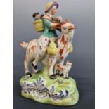 19TH CENTURY STAFFORDSHIRE POTTERY FIGURE OF THE WELCH TAYLER'S WIFE, RIDING ASTRIDE A GOAT. 17 cm