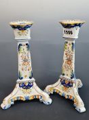 A PAIR OF QUIMPER FLORAL CANDLESTICKS RAISED ON THREE FEET. H 14cms.