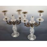 A PAIR OF CUT GLASS AND BRONZE TWO LIGHT LUSTRE CANDELABRA SUPPORTED ON PETAL FEET. H 34cms.